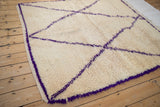 Plush ivory pile and pronounced violet purple diagonal lines of a vintage Moroccan carpet.