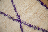 Moroccan rug's thick ivory pile with violet diagonal pattern and selvage.