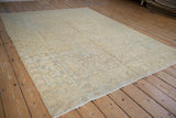 Angled perspective on a distressed Mehrivan rug with a soft, faded geometric floral pattern.