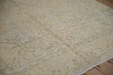 Close view of the distressed pile showing mostly even wear over geometric patterns in cream and silver.