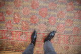 Distressed Khotan runner with faded floral blossoms, purple, cherry red, and gold patina.