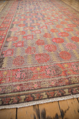 Distressed Khotan rug runner's short end with worn geometric border and light fringe.