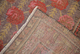 Hand-knotted foundation and distressed floral pile with faded purples, reds, and gold.
