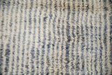 Close-up of Moroccan rug runner's shaggy pile with ivory, silver, and charcoal abrashes.