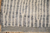 Textured ivory and charcoal Moroccan rug pile with abrash, above geometric kilim end.