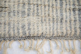 Ivory braided fringe, charcoal patterned woven band, and thick pile of a vintage Moroccan runner.