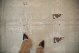 Distressed pale seafoam green Moroccan rug, dark chocolate geometric buds, visible threadbare spots.