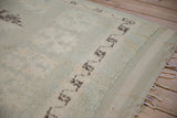 Shaggy seafoam green pile with dark brown geometric motif, flatweave, and distressed fringe.