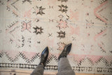 Detailed view of a distressed Moroccan rug showing worn low pile and exposed knot heads.
