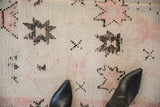 Textural detail of a distressed Moroccan rug showing low pile and the visible ivory foundation.