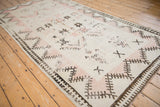 Angled view of a distressed Moroccan runner highlighting its low pile and geometric border.