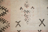 Distressed texture of a vintage Moroccan rug showing worn pile, knot heads, and exposed foundation.