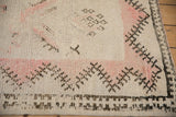 Visible foundation and knot heads on a distressed vintage Moroccan rug with pale rose and brown motifs.