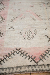 Low pile texture and starburst designs in pale rose and dark brown on a vintage Moroccan rug.