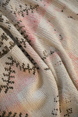 Textured knot heads and exposed ivory foundation on a draped vintage Moroccan rug runner.