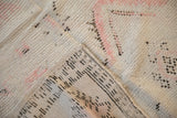 Folded corner of a Moroccan rug showing the woven cheesecloth foundation and distressed pile.