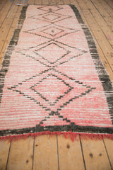 Textured vintage Moroccan runner pile with charcoal border and pink diamond motifs.