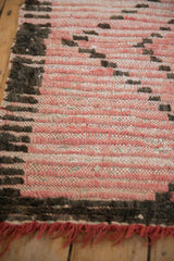 Detail of the vintage Moroccan rug's chunky pink and dark wool pile over colorful woven wefting.