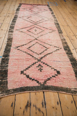 Textured pink wool pile with dark charcoal border on vintage Moroccan runner.