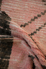 Textured pink wool pile and charcoal geometric pattern on a Moroccan rug runner.