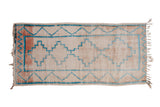 Vintage Moroccan runner, turquoise stepped medallions and chevron borders on a worn light field.