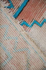 Vintage Moroccan runner's wool pile with turquoise chevron, revealing striped cotton foundation.