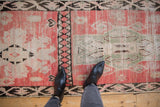 Low pile and hand-knotted texture of a vintage Moroccan runner in blush, charcoal, and seafoam green.
