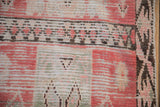Textured hand-knotted pile and restored side cord on a Moroccan rug in pink and brown.
