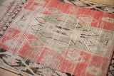 Low pile and visible knot heads of a vintage Moroccan runner in blush and sea foam green.