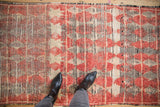 Detailed view of the vintage Moroccan rug's hand-knotted pile, showing cherry red diamond motifs.