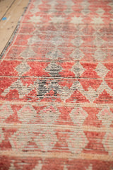 A close-up of the textured, hand-knotted pile on a vintage Moroccan rug showing visible knot heads and abrashes.