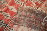 The handwoven, striped foundation of a vintage Moroccan rug runner revealed at the corner.
