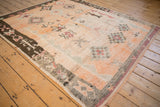 Side angle of a vintage Moroccan carpet showing textured pile and geometric diamond medallions.