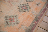A vintage Moroccan rug's even pile texture, with a checkered diamond medallion and side cord selvage.