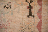 Texture detail of hand-knotted wool pile with geometric motifs in brown, ivory, and dusty red.