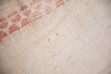 Distressed blush pink pile texture transitioning to ivory plain-woven flatweave.