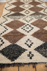 Thick hand-knotted wool pile displaying natural brown and ivory geometric diamonds.
