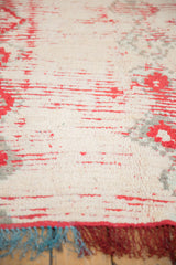 Close view of the plush, hand-knotted pile, showing the knot heads, red motifs, and teal fringe.
