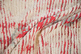 A close-up of the thick, hand-knotted pile and knot heads of a vintage Moroccan rug.