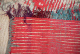 Plain weave back and colorful fringe in purple, burgundy, and teal on a vintage Moroccan carpet.