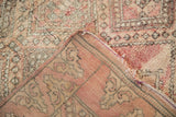 Moroccan rug folded corner, showing shaggy pink pile and flat woven foundation, side selvage.