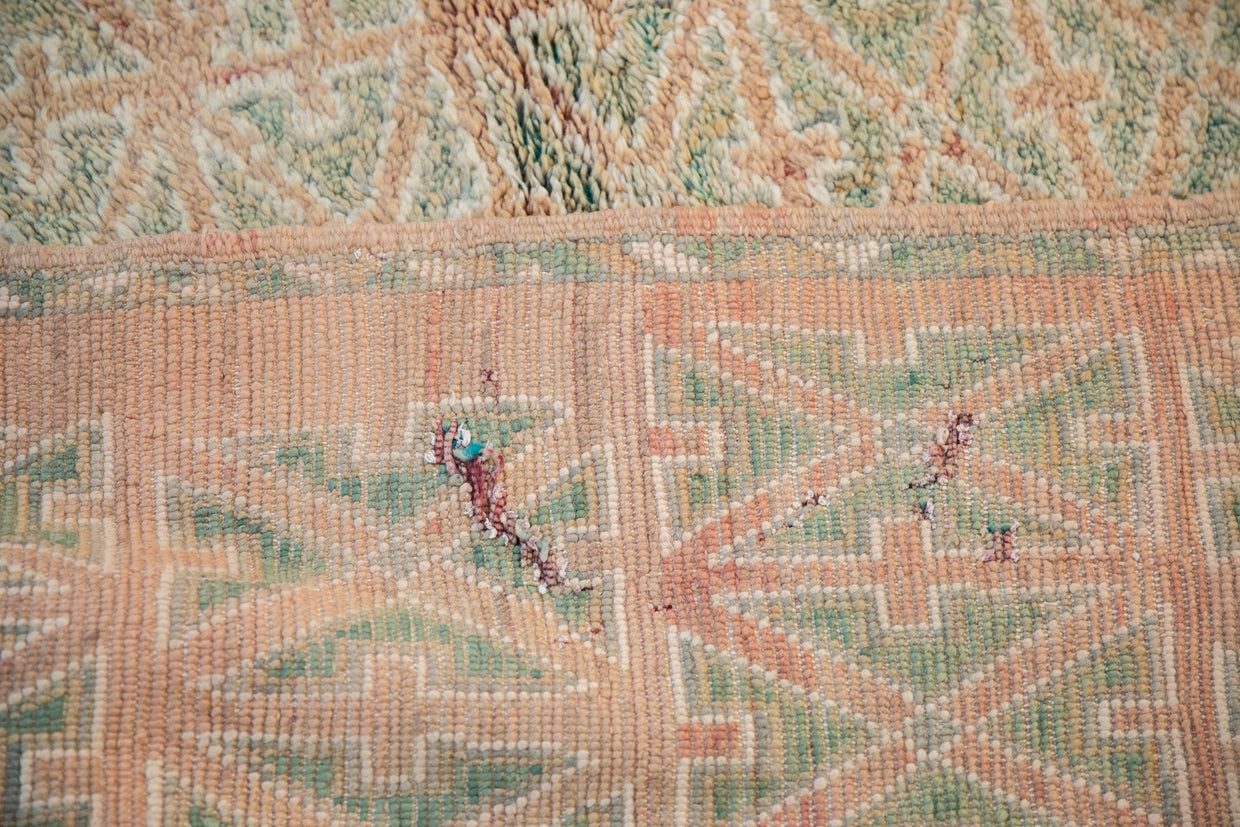 Distressed Moroccan carpet, ivory, dusty rose, jade green geometric floral pile with woven back.