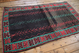 Vintage Moroccan rug with central vines, a charcoal abrashed field, and a turquoise crab-style border.