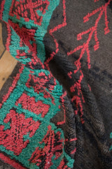 Textured close-up of the hand-knotted pile on the turquoise border with cherry red geometric motifs.