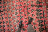 Detailed texture of a hand-knotted Moroccan rug with cherry red and charcoal mountain designs.