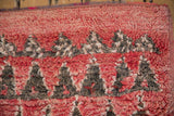 Close-up of the shaggy, hand-knotted pile showing the mountain design in red and charcoal.