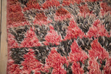 Thick, shaggy wool pile of a vintage Moroccan rug in cherry red, charcoal, and ivory.