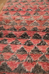 Plush hand-knotted wool pile on a Moroccan carpet in shades of red, charcoal, and silver.