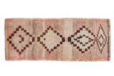 Vintage Moroccan runner with multi-medallions, checkered outlines, pink accents on an abrash ivory-beige ground.