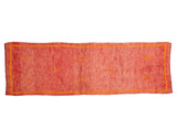 Vintage Moroccan runner in faded cherry red with orange geometric motifs and narrow border.